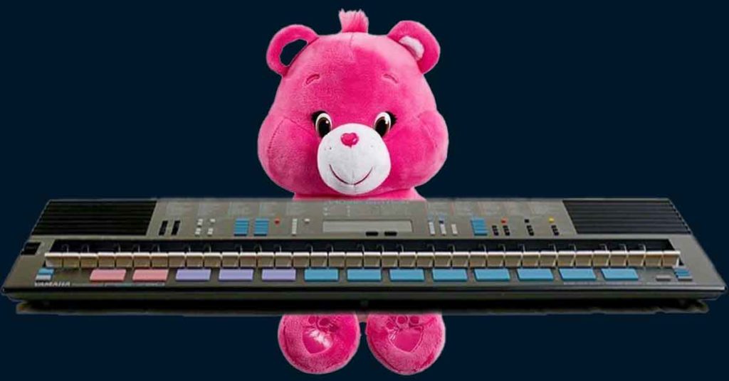 Image of a Care Bear sitting at a Yamaha PSS 780 with a dark blue background