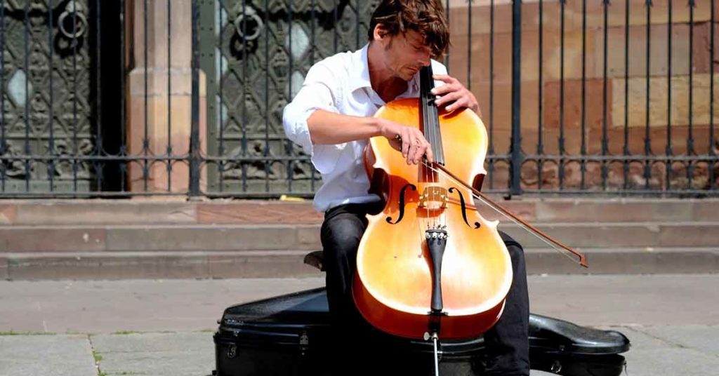 Street musician playing the cello with a focussed look on his face