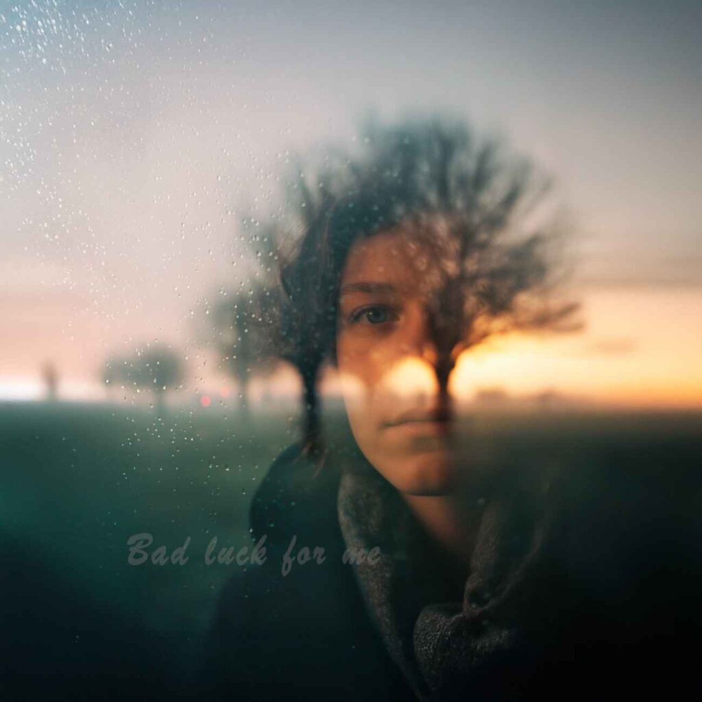 Sunset field with blurred oak trees and a softly blurred woman emerging from the background, featuring the handwritten title Bad Luck for Me.